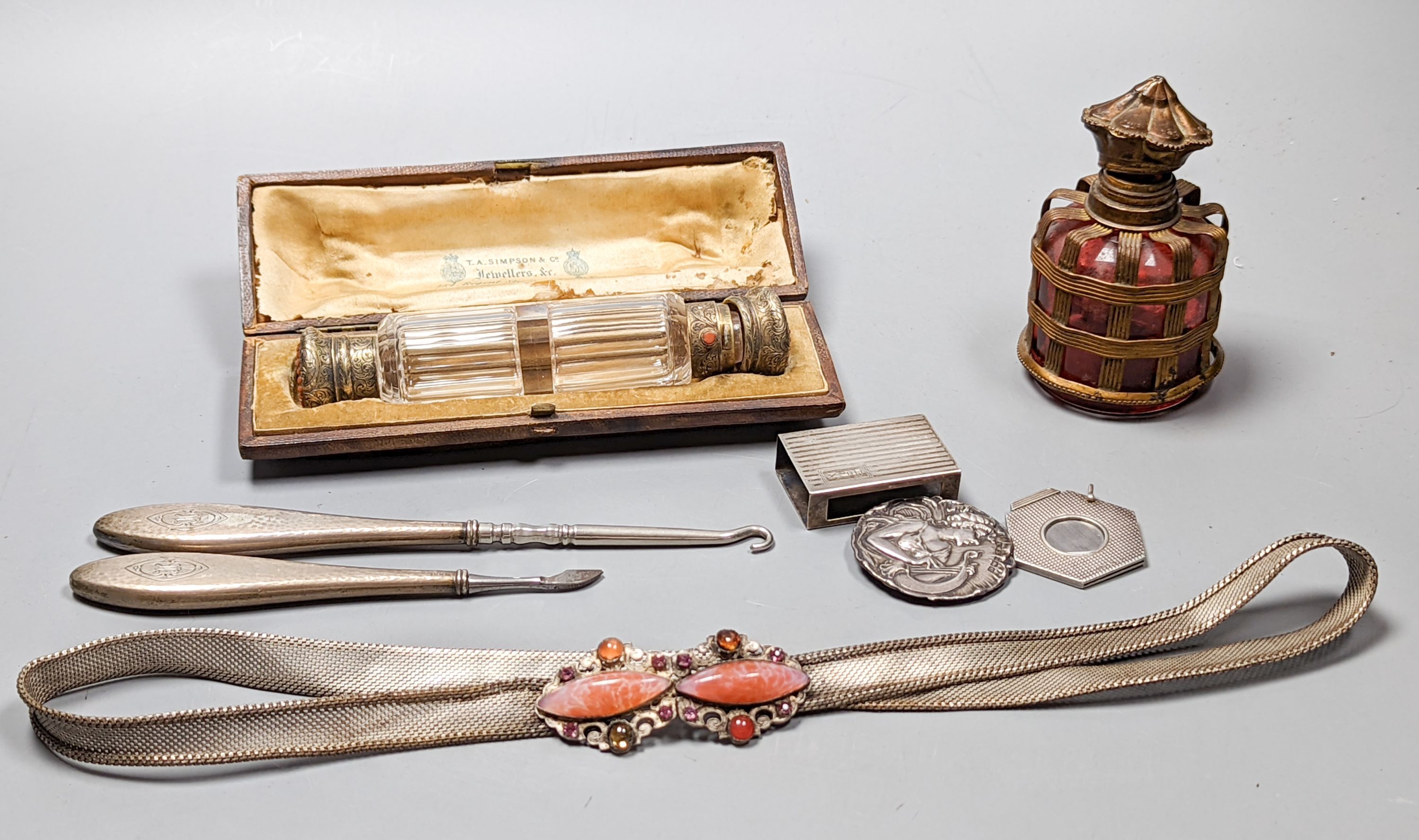 A cased Victorian engraved gilt white metal and coral set double ended scent bottle, 13.4cm, a silver cigar cutter, a belt, a silver buckle, gilt and cranberry perfume bottle, etc.